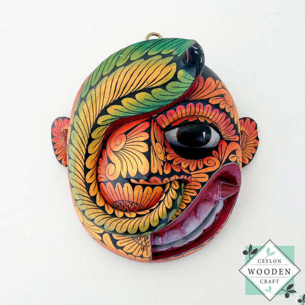 Inspired by Sri Lanka’s traditional Bihiri Sanni masks, this hand-carved and hand-painted wooden snake mask brings boho charm and cultural depth to any wall space.