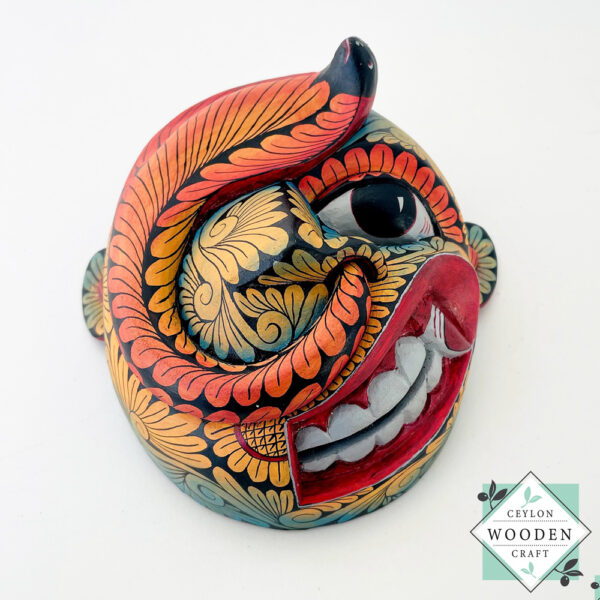 Inspired by Sri Lanka’s traditional Bihiri Sanni masks, this hand-carved and hand-painted wooden snake mask brings boho charm and cultural depth to any wall space.