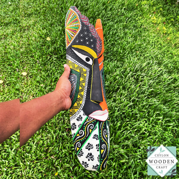 Hand-carved tribal mask made from kaduru wood. Colorful, lightweight, and perfect for boho or ethnic home decor. Available in 3 sizes.