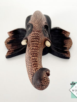 Hand-carved wooden elephant face sculpture with tusks. Made from mahogany wood. A symbol of luck and wisdom. Perfect for home decor or gifting.